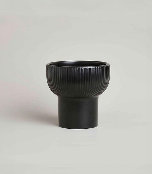 Sleek black ceramic planter with fluted bowl and pedestal base