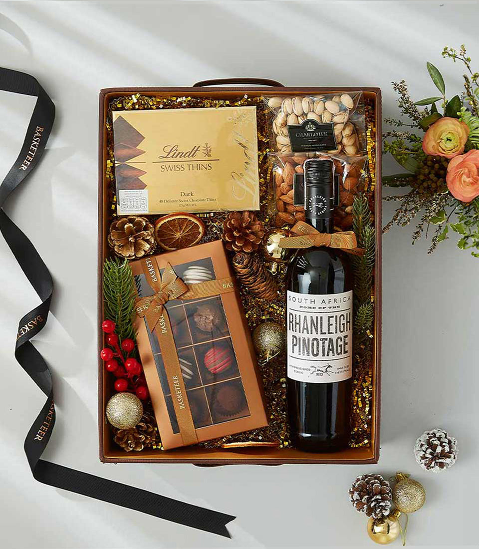 Luxury red wine gift box with gourmet chocolates, nuts, and festive gold accents