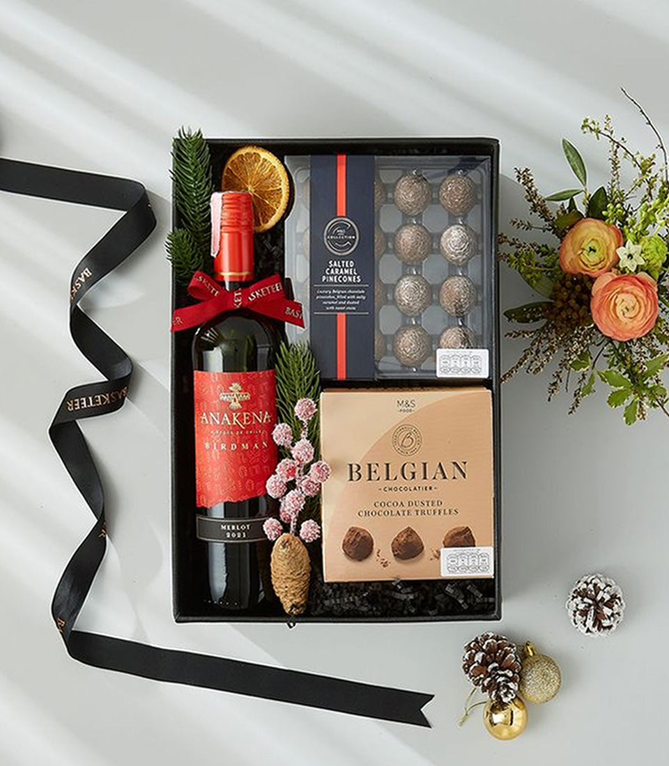 Premium red wine and Belgian chocolate gift hamper with festive black box and holiday florals