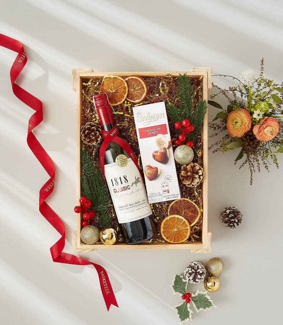 Festive wine gift box with red wine, Belgian chocolate, dried citrus, and holiday florals