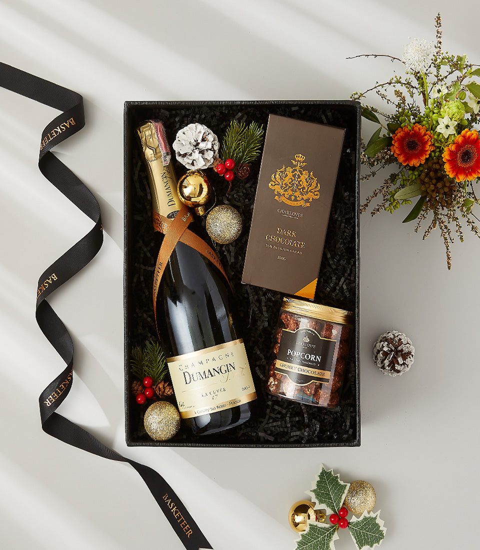 Luxury black gift box with Dumangin Champagne, dark chocolate, and gourmet popcorn, gold ribbon and festive decorations