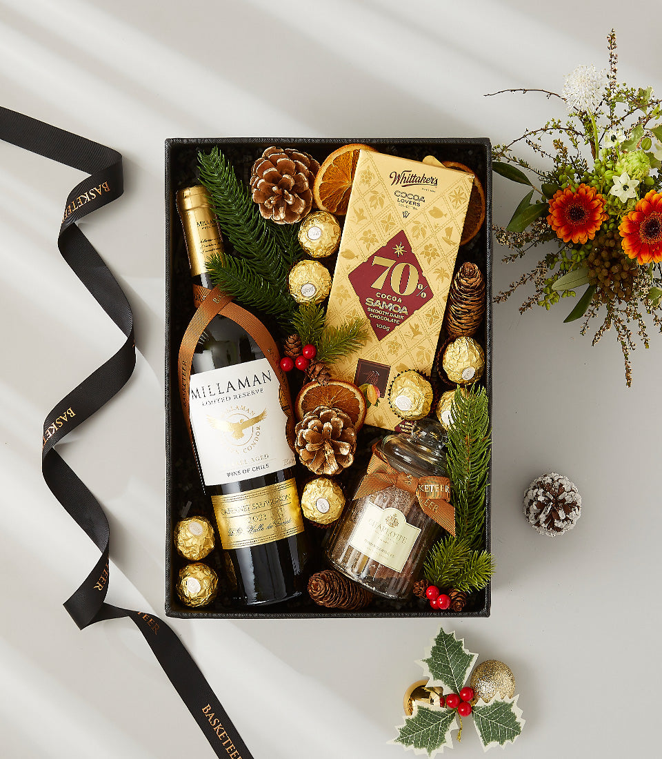Premium wine gift box with red wine, chocolates, and festive gold accents