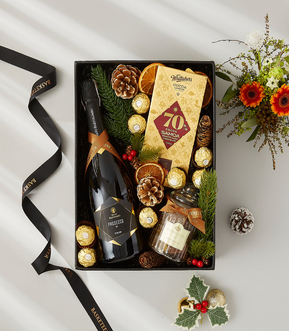 Luxury holiday gift hamper with Prosecco, gold chocolates, and festive pine cone accents