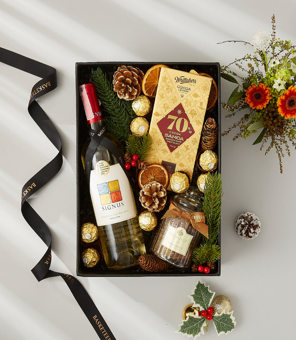 Premium white wine gift box with Whittaker's chocolate, dried spices, and holiday greenery