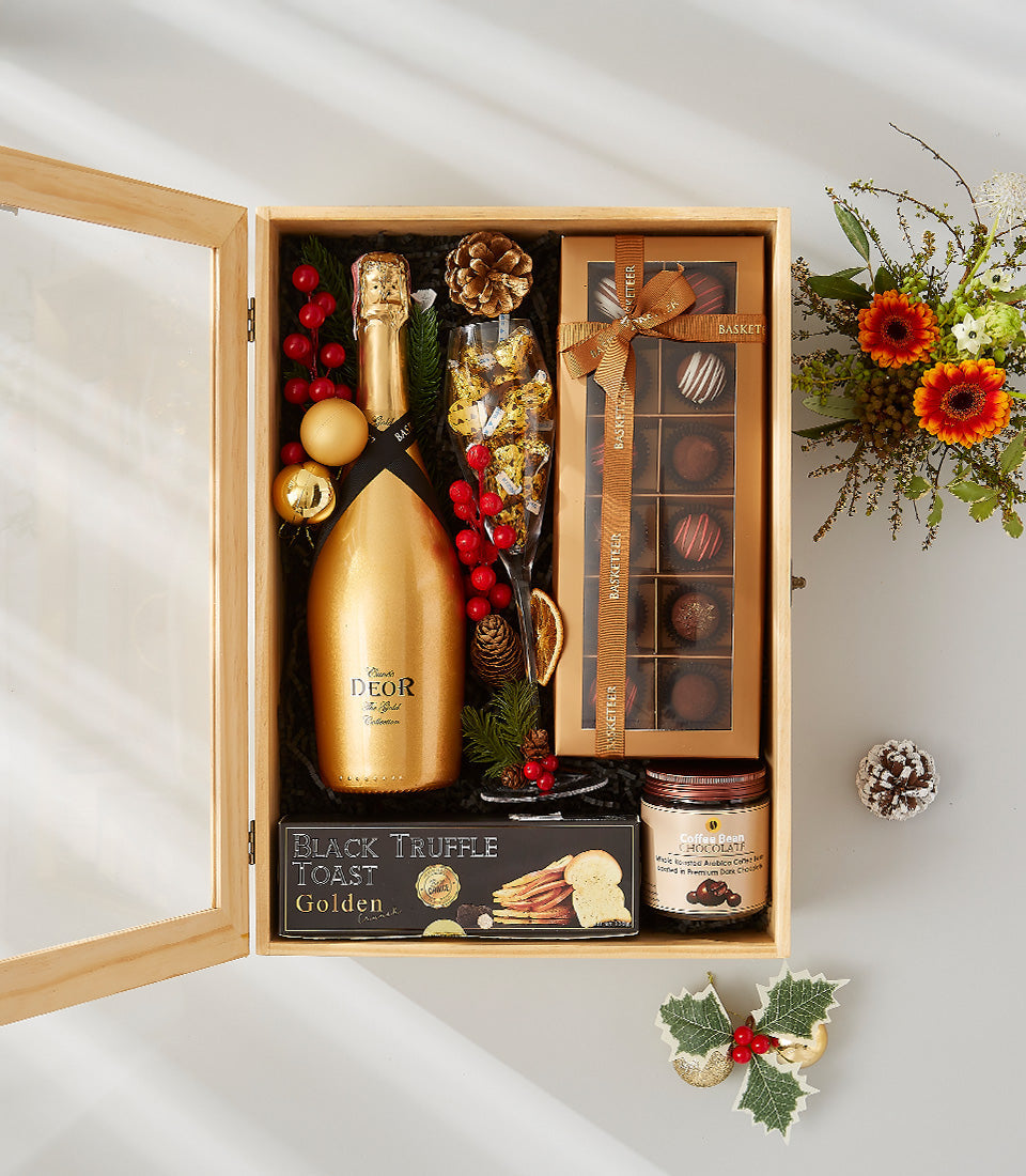 Luxury champagne gift box with golden bottle, gourmet chocolates, truffles, and chocolate-covered cherries