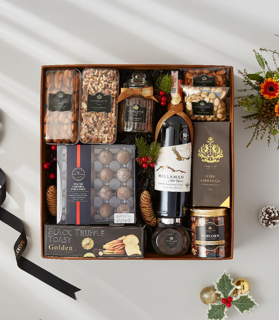 Luxe wooden gift box with red wine, gourmet chocolates, nuts, truffle crackers and festive garnish
