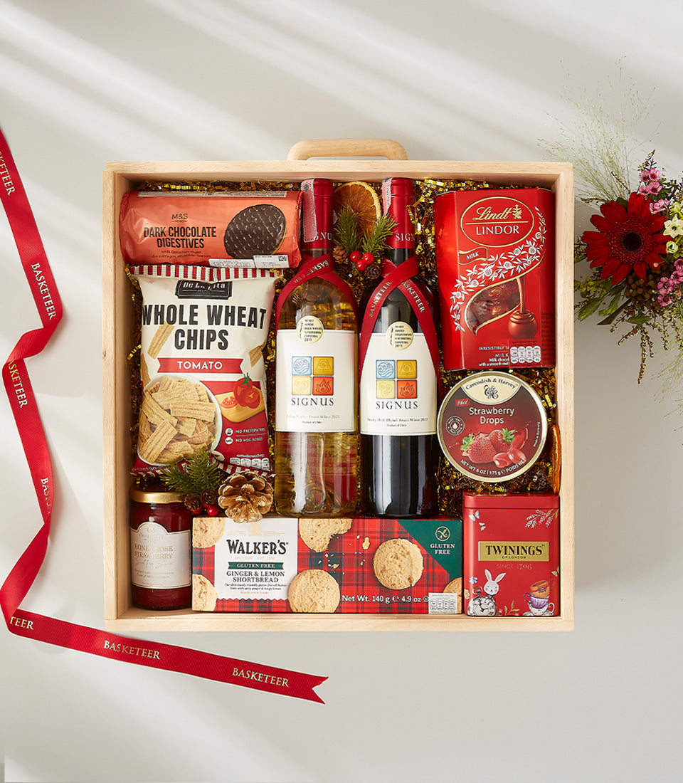 Wooden gift box with red and white wine, gourmet chocolates, jam, tea, and crackers with festive ribbon