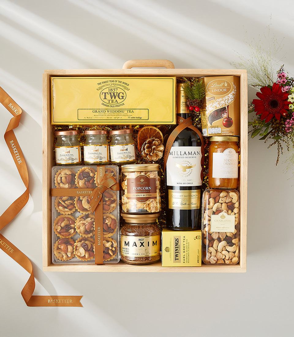 Premium gourmet gift hamper with red wine, artisan preserves, chocolates, and specialty foods in wooden crate