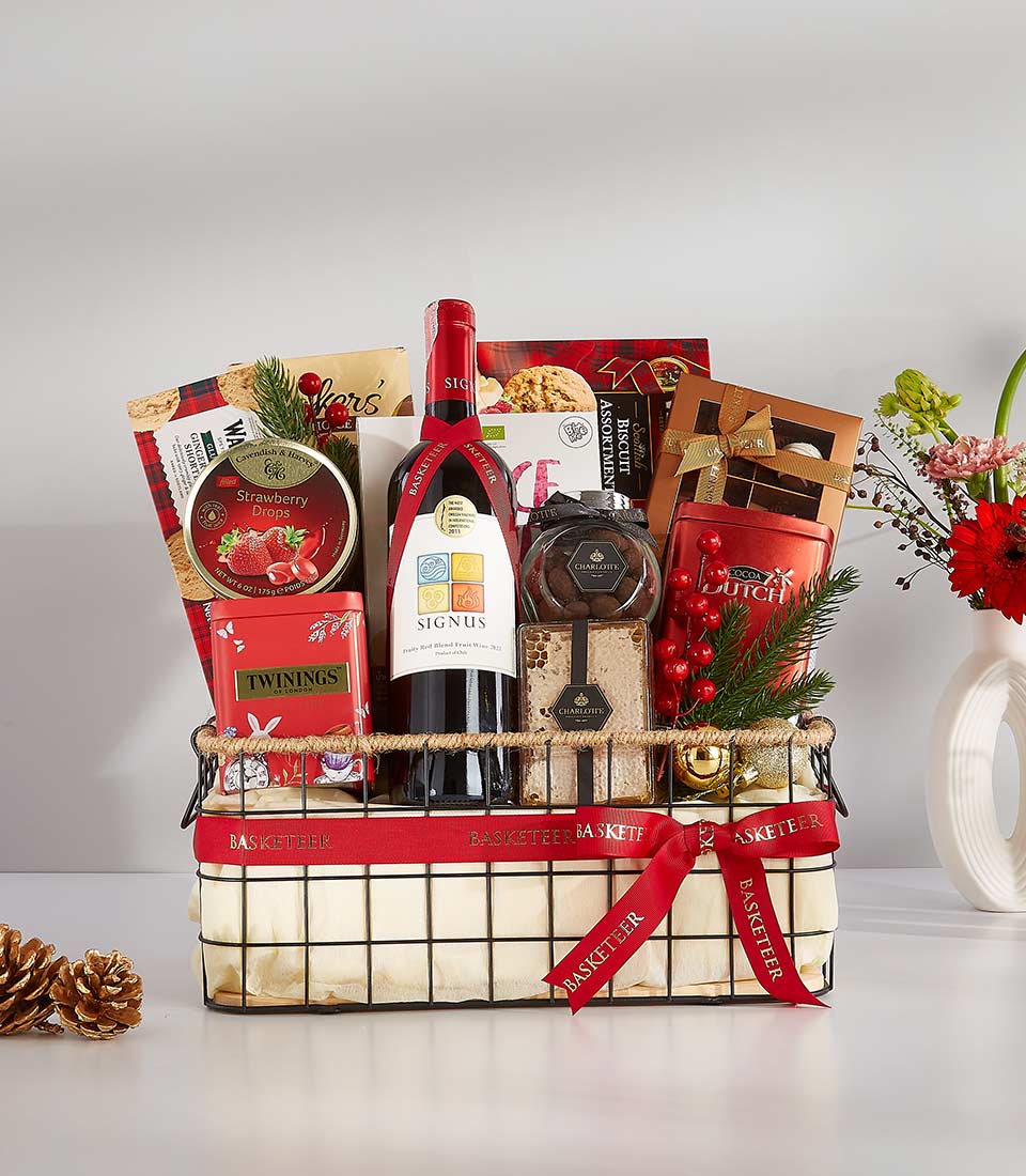 Classic Red wine gift basket with gourmet treats, strawberry drops, tea, chocolates, and festive berries