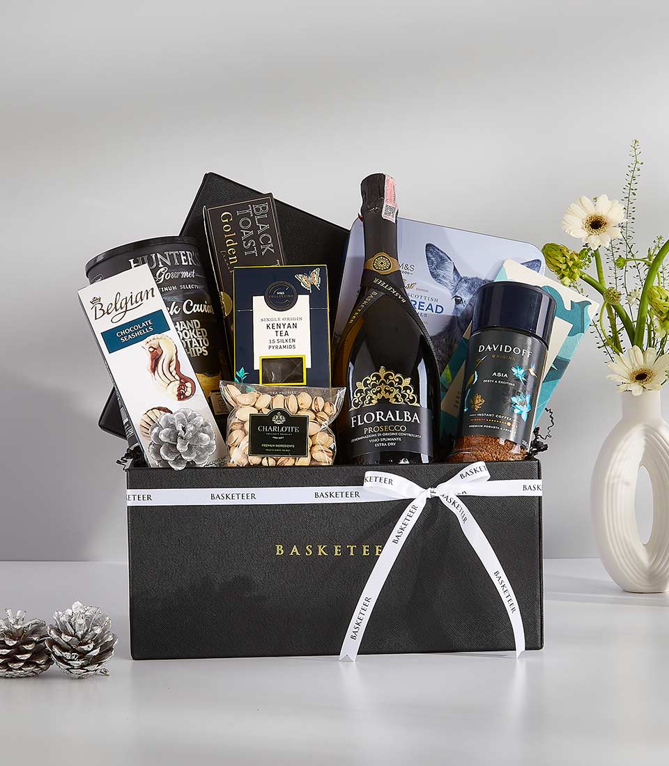 Luxury black gift hamper with Prosecco, Belgian chocolate, Kenyan tea, and gourmet treats, tied with white ribbon