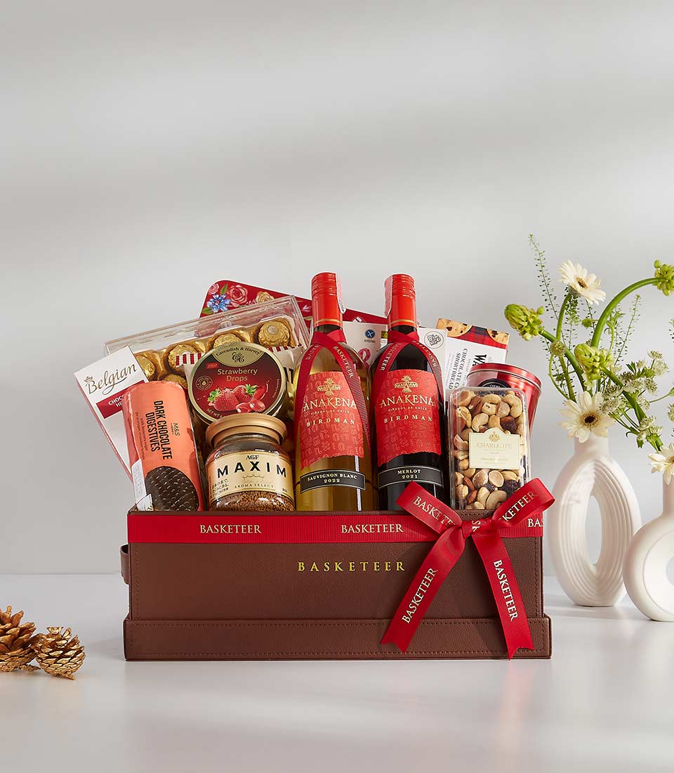 Luxury wine gift basket with red and white bottles, gourmet chocolates, coffee, and nuts in dark brown leather case