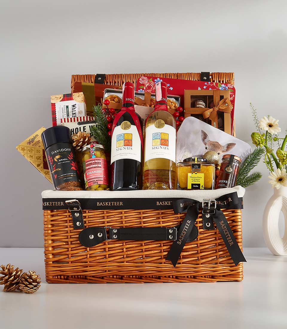 Luxury wicker gift basket with Signus red and white wines, gourmet foods, and festive décor