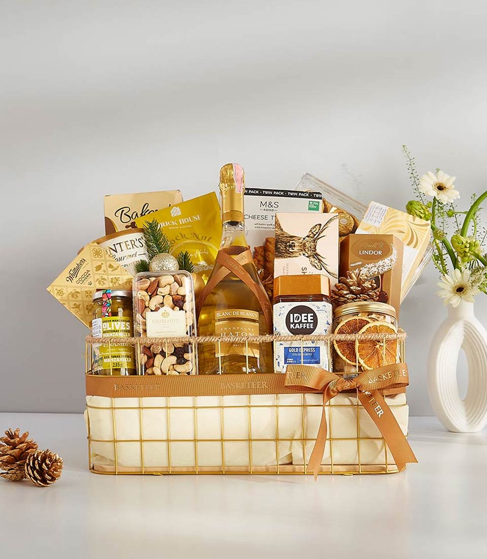 Luxe gold wire basket with Blanc de Blancs champagne, gourmet chocolates, nuts, olives, and artisan coffee