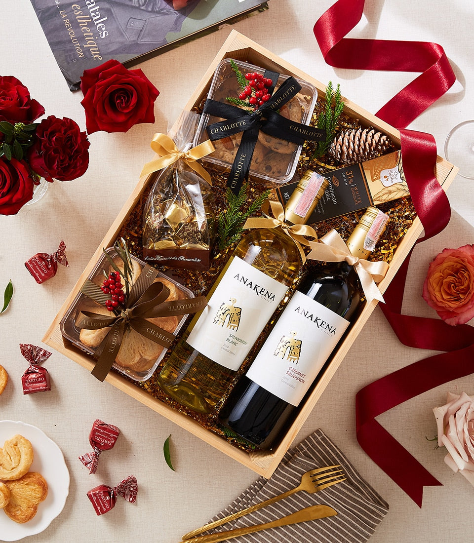 Luxury wooden wine and cookie gift box with red and white wine, artisan cookies, chocolates, and festive greenery