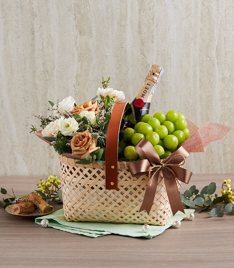 Moët champagne gift basket with fresh flowers, green grapes, and woven bamboo basket