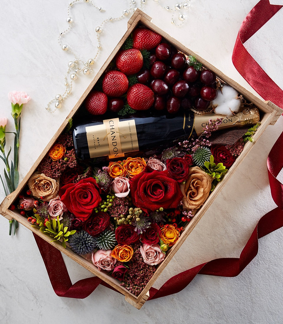 Chandon sparkling wine gift box with fresh red strawberries, grapes, and red roses in wooden crate