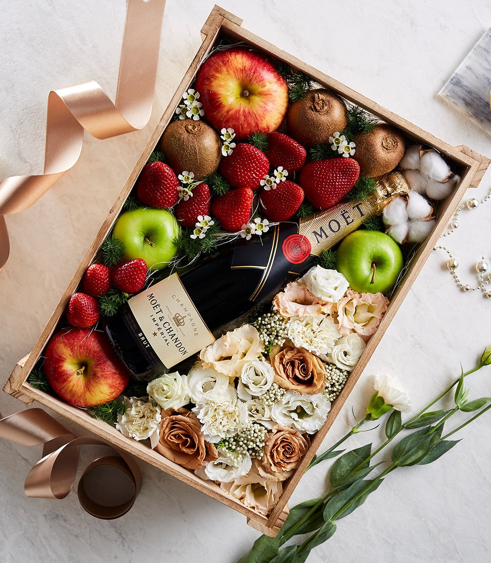 Moët & Chandon champagne gift box with fresh strawberries, apples, cream roses, and pearl ribbon
