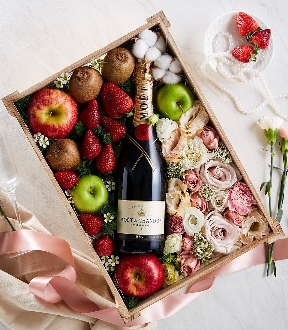 Premium gift box with Moët champagne, fresh roses, seasonal fruit, and cotton florals