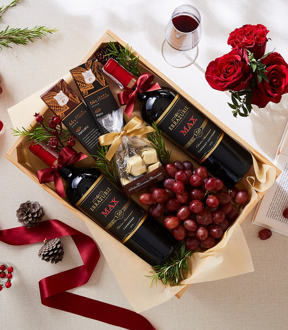 Fruitful wine and chocolate gift box with red wine, dark chocolate, white chocolates, and fresh grapes in wooden crate