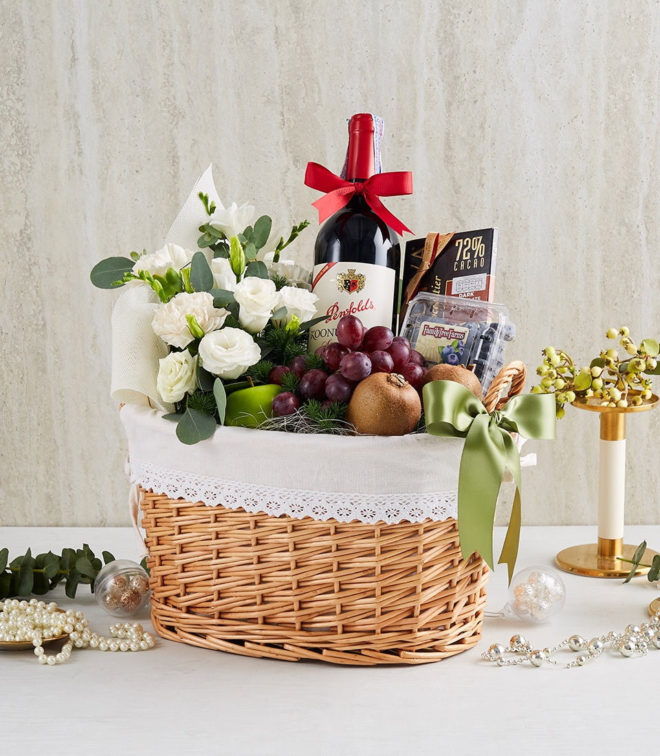 Penfolds red wine gift basket with fresh roses, gourmet chocolates, and seasonal fruits in wicker