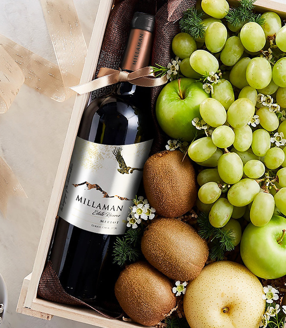 Elegant red wine gift box with green grapes, kiwis, apples, pear and fresh florals in wooden presentation case