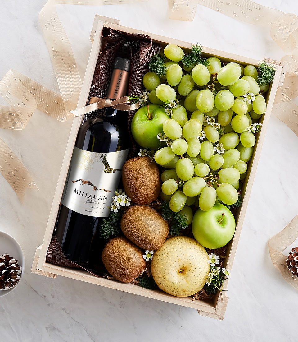 Elegant wooden wine gift crate with Merlot bottle, green grapes, apples, kiwis and pear