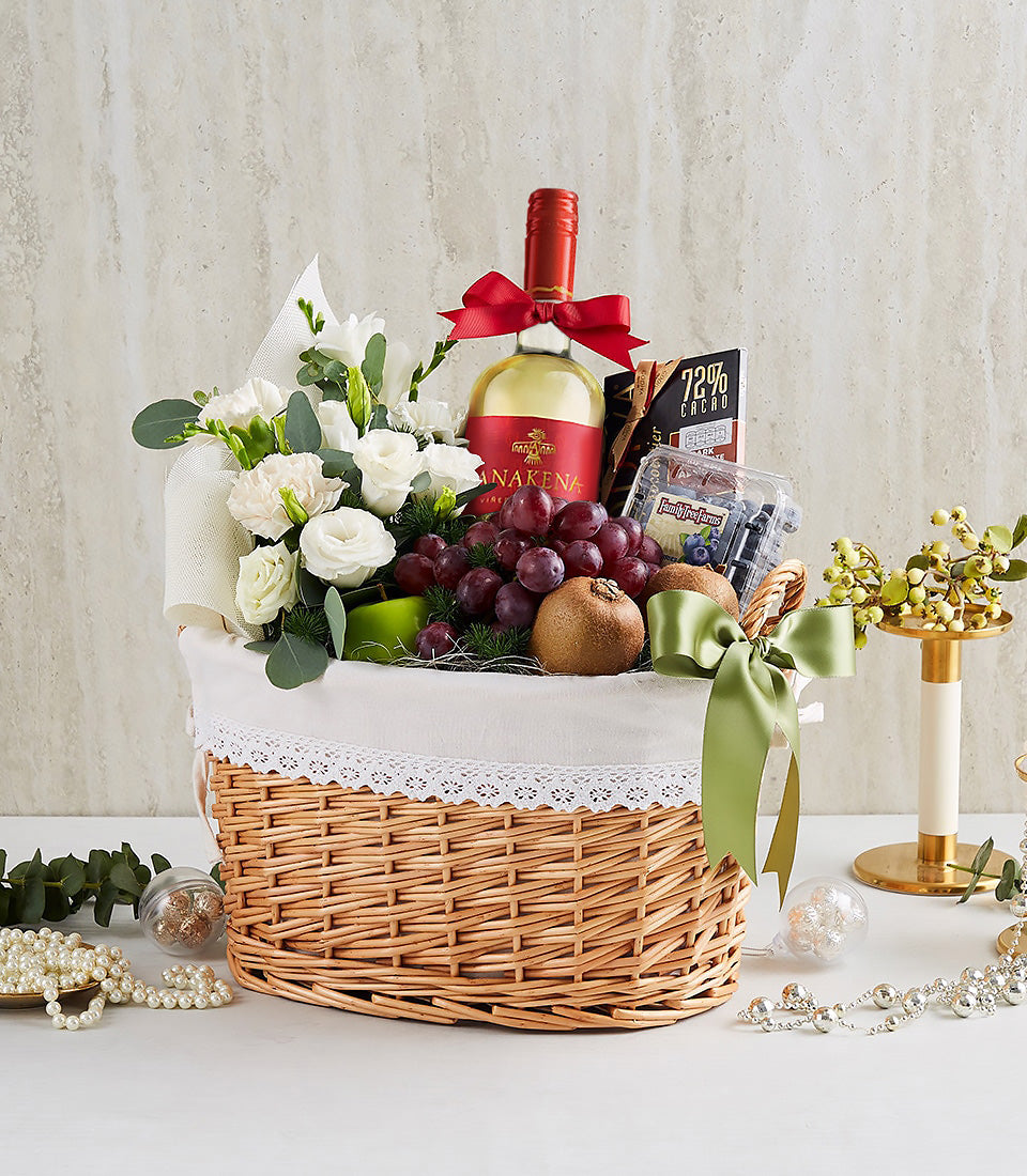 Luxury white wine gift basket with roses, fresh fruits, chocolate, and gourmet treats in wicker