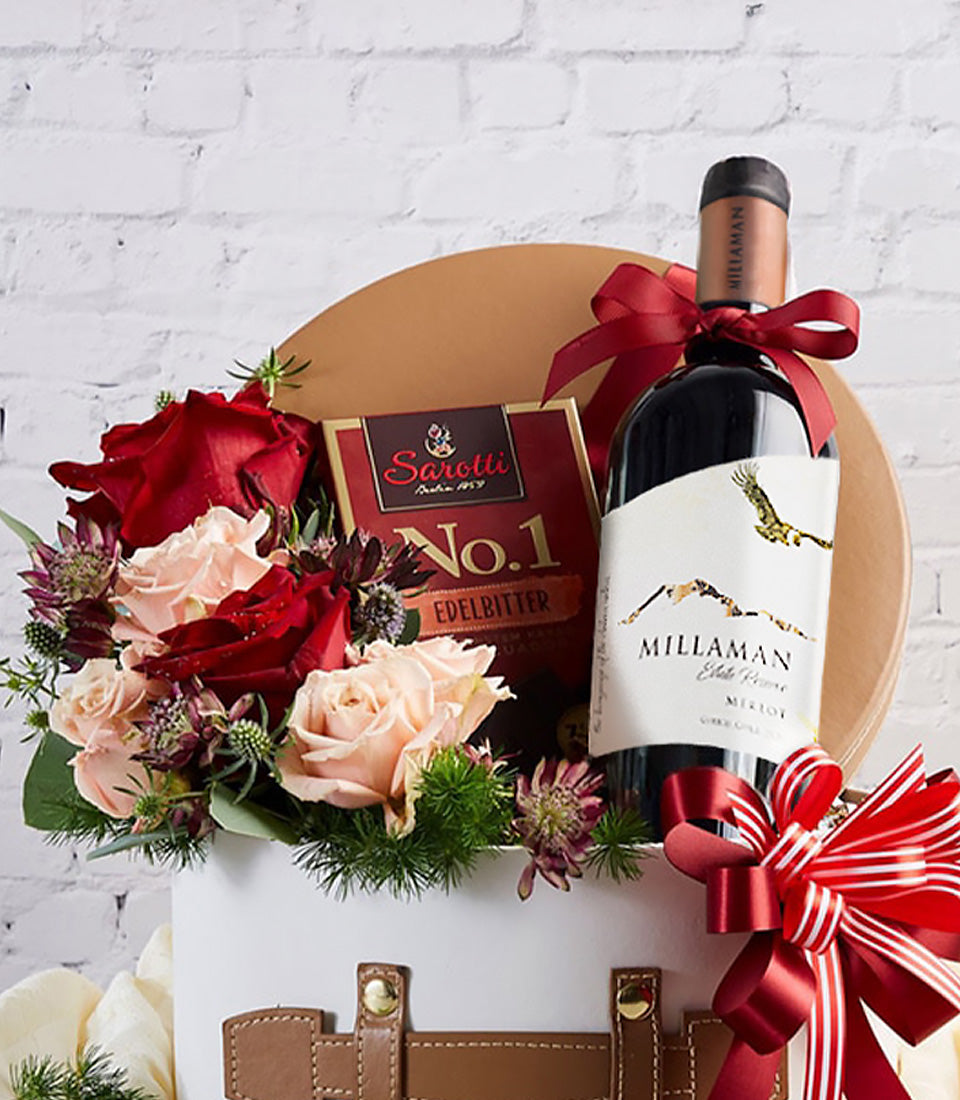 Elegant red wine, dark chocolate, and red rose bouquet in luxury white gift box with leather accents for anniversaries