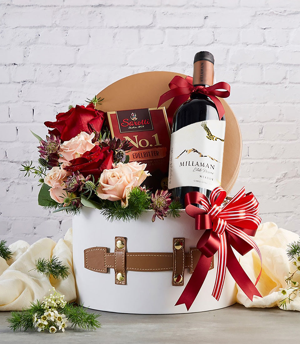 Elegant red wine, dark chocolate, and fresh roses in luxury white gift box with red ribbon bow, perfect for anniversaries