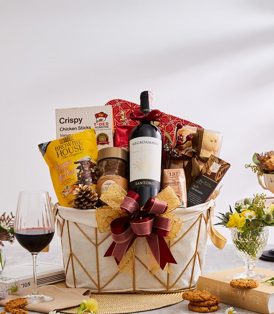 Premium red wine with gourmet crackers, chocolate, and coffee in luxury gift basket