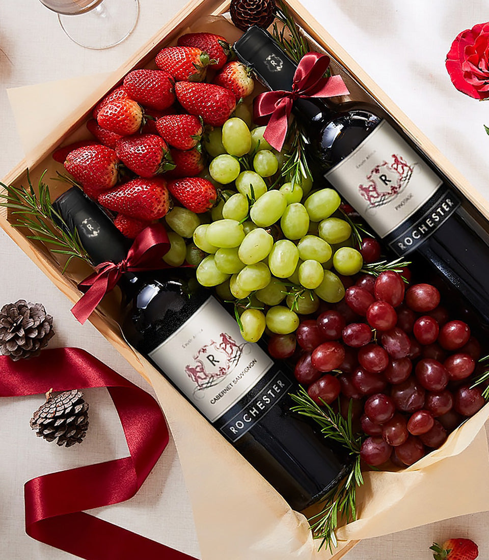Luxury wooden gift box with Rochester red wine bottles, fresh strawberries, grapes, and rosemary