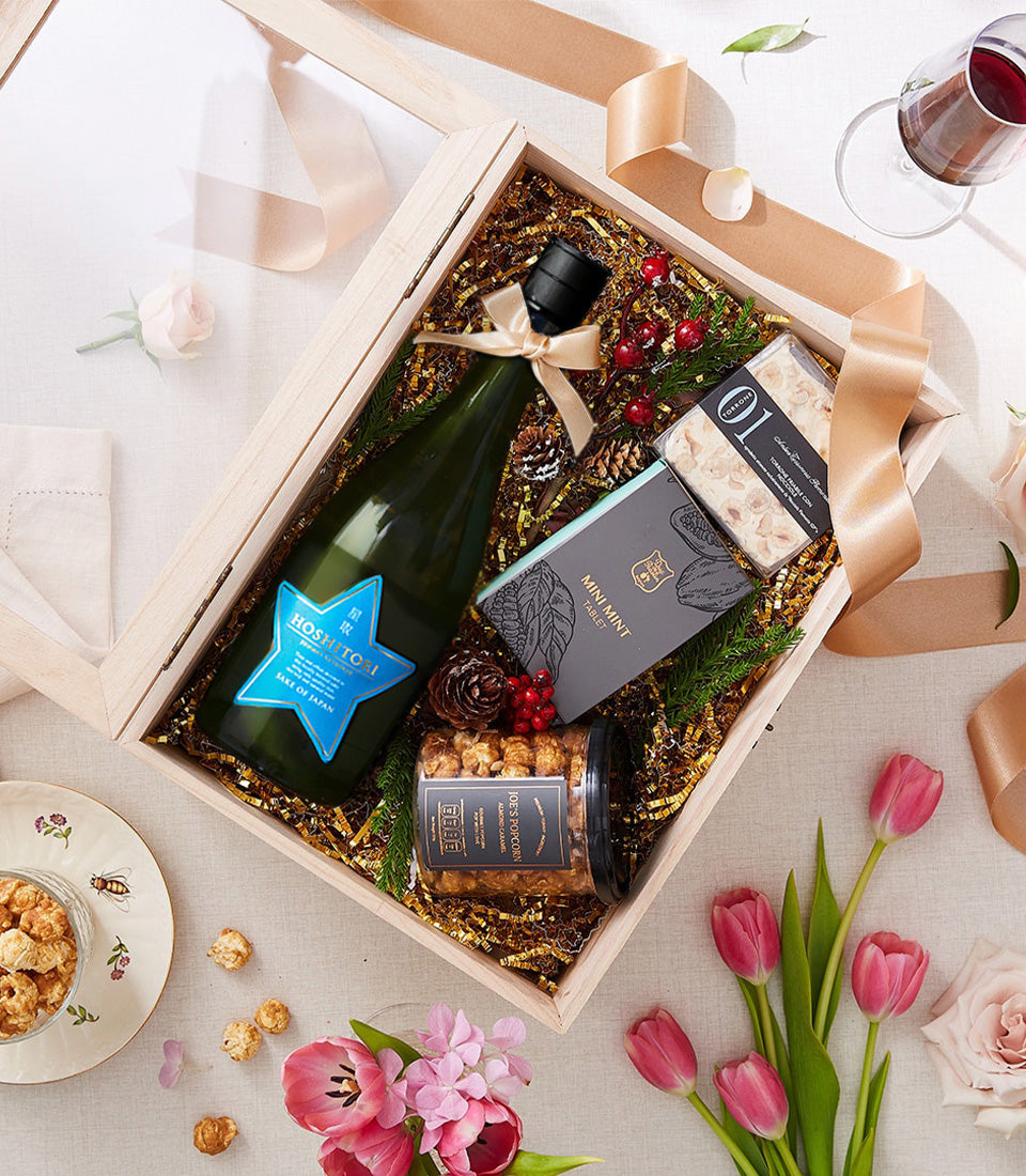 Luxury Japanese sake gift box with mint tablets, caramel popcorn, nougat, and fresh flowers