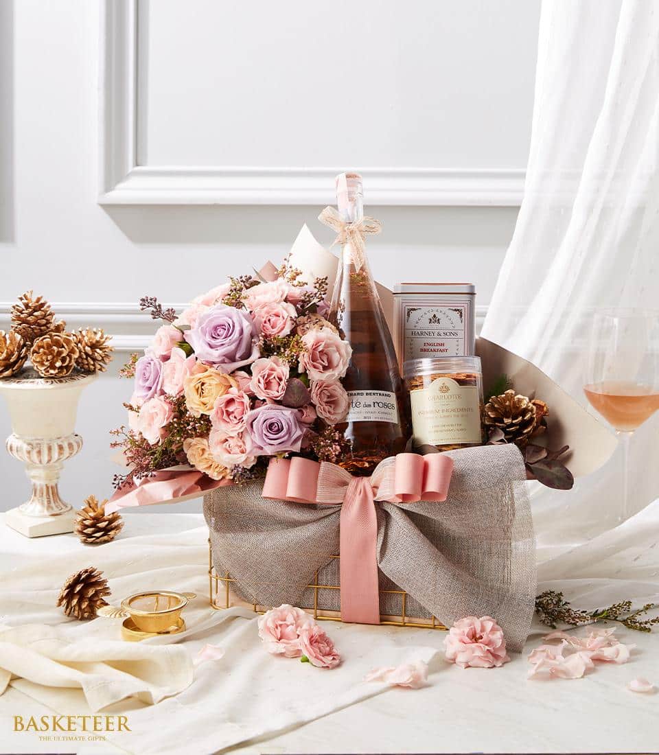 Luxury gift basket with pink and lavender roses, sparkling wine, premium shortbread, and English breakfast tea