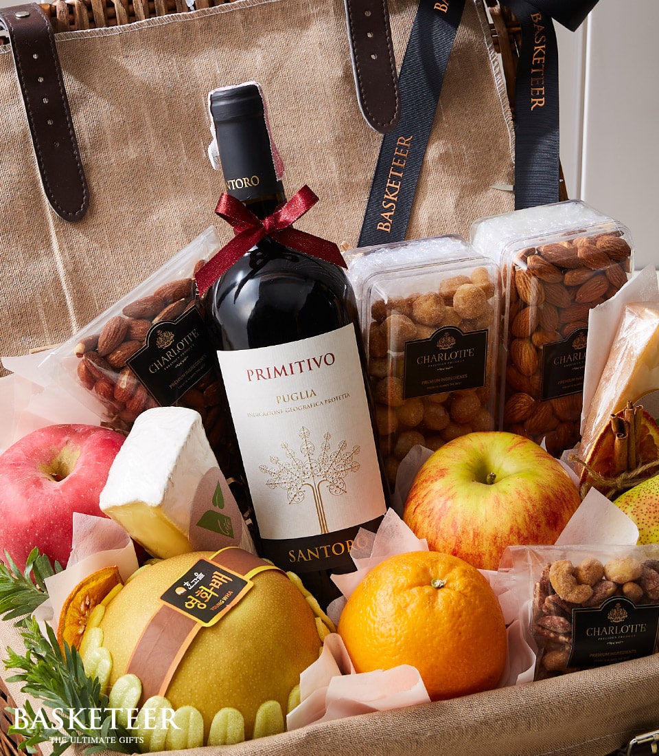 Primitivo Puglia red wine with artisan cheese, fresh fruit, and roasted almonds in luxury gift basket
