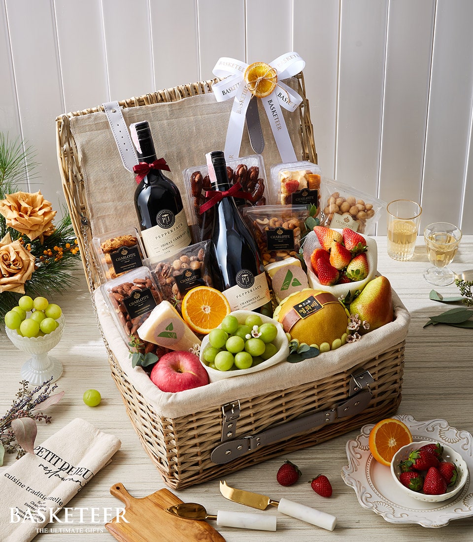 Premium wine and gourmet fruit hamper with red and white wines, artisan cheeses, fresh produce, and snacks in wicker basket