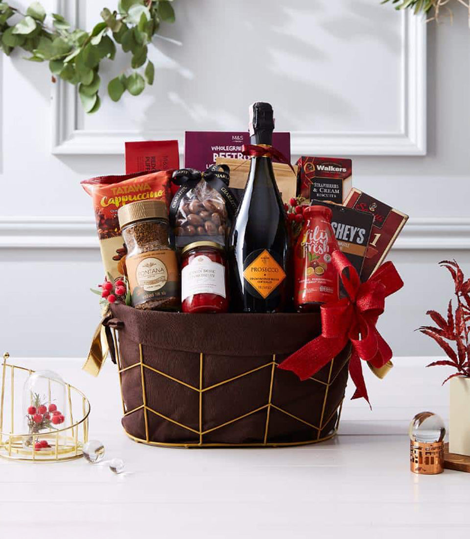 Prosecco celebration gift basket with sparkling wine, gourmet treats, and fresh red berries in gold wireframe design