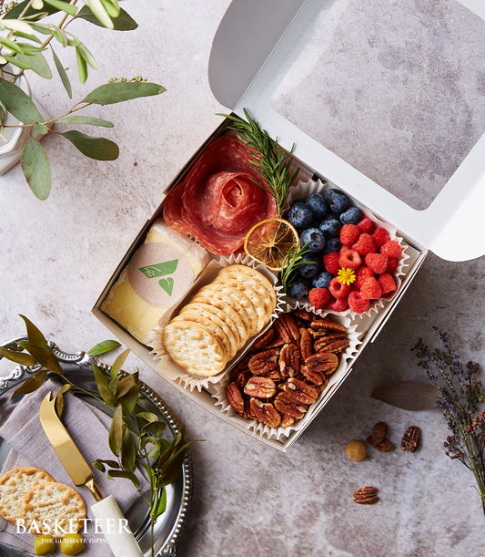 Luxury mini charcuterie gift box with artisan cheese, cured meats, fresh berries, and candied pecans in compartments