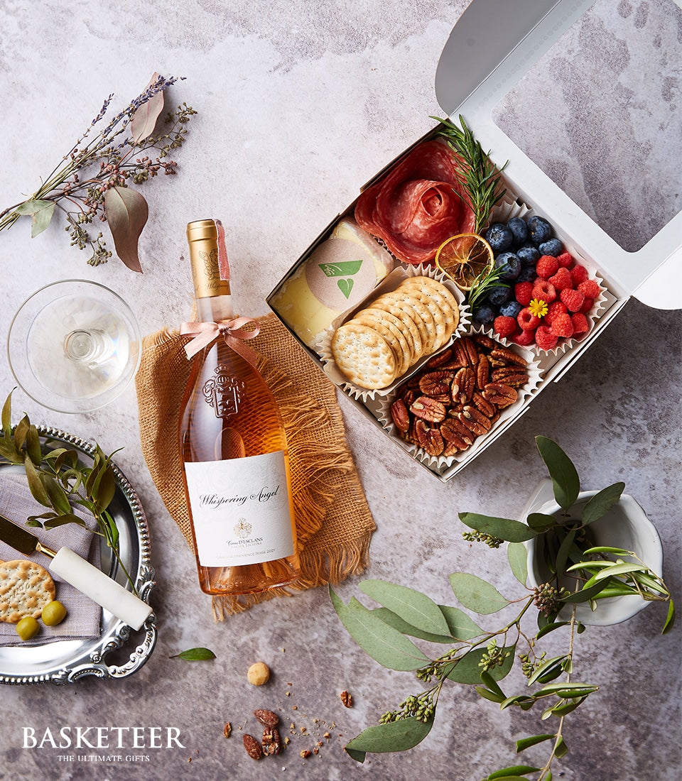 Premium rosé wine gift set with gourmet charcuterie, cheese, crackers, and fresh berries in white presentation box