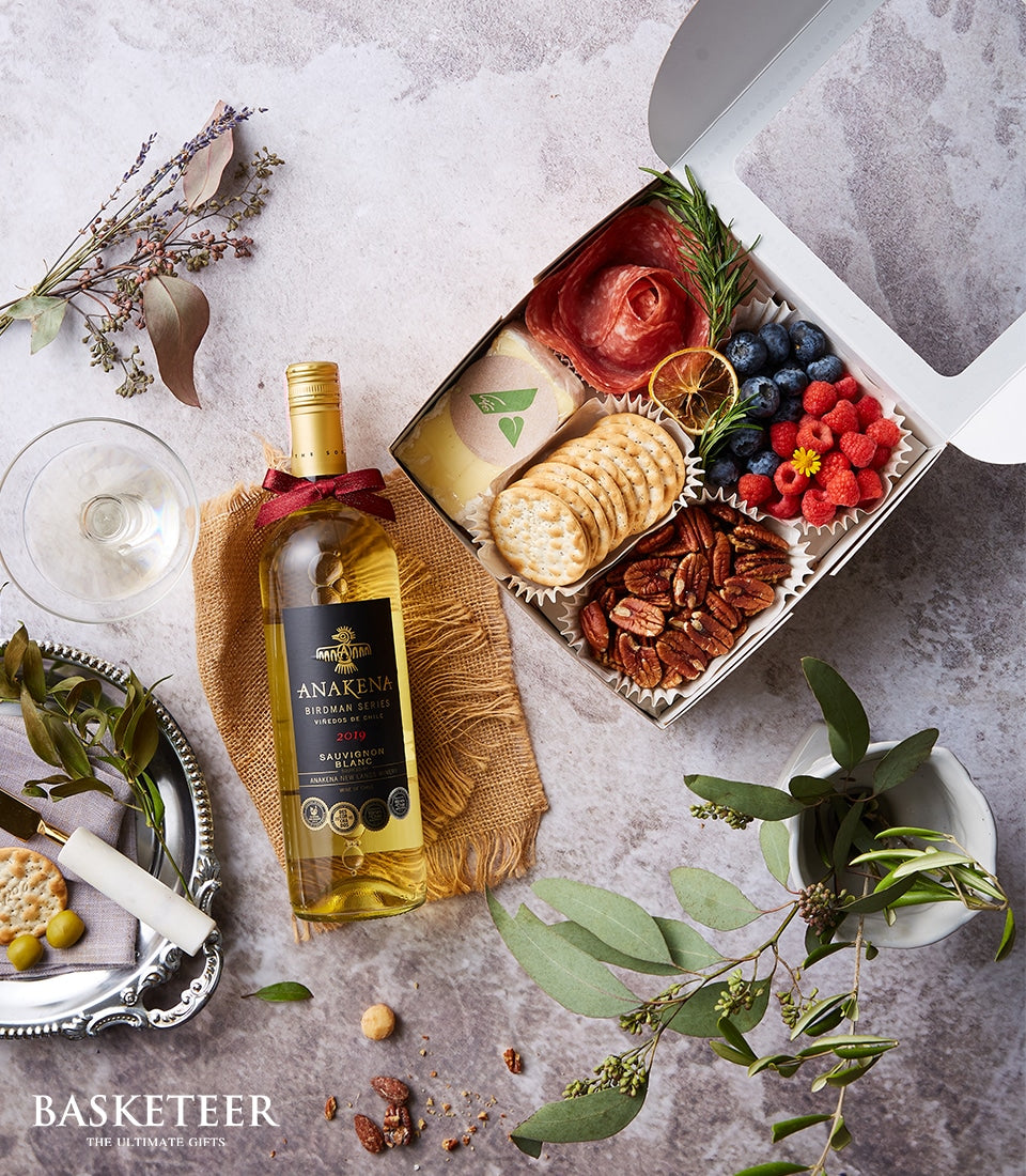 Premium white wine and charcuterie gift box with cheese, cured meats, berries, and crackers