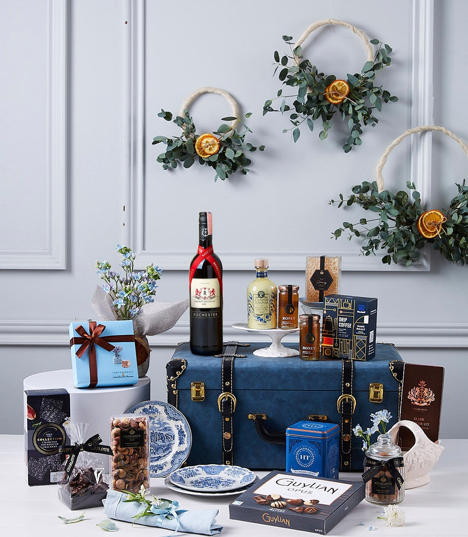Premium red wine and gourmet hamper with spirits, artisan chocolates, and honey in vintage blue trunk