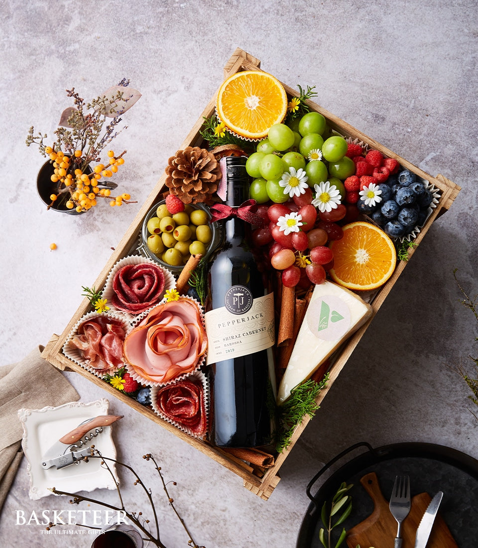 Premium wine and charcuterie gift box with Shiraz, aged cheeses, cured meats, fresh berries, and olives in wooden crate