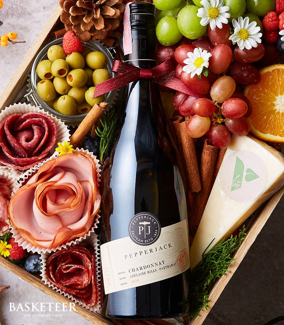 Premium cheese and charcuterie gift hamper with red wine, fresh grapes, olives, and artisan meats in wooden tray