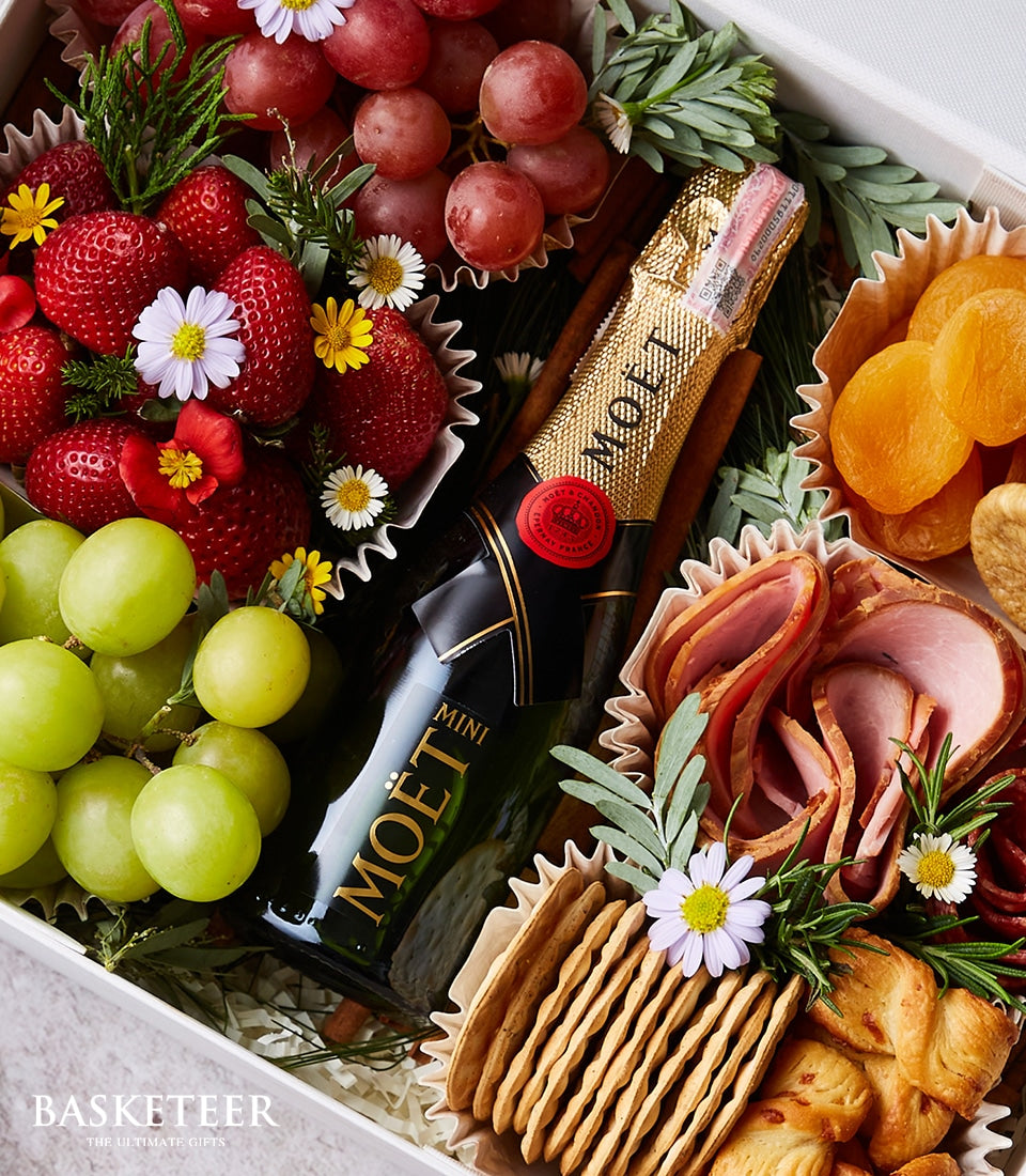 Luxury champagne charcuterie box with Moët & Chandon, fresh strawberries, grapes, cured meats, and crackers
