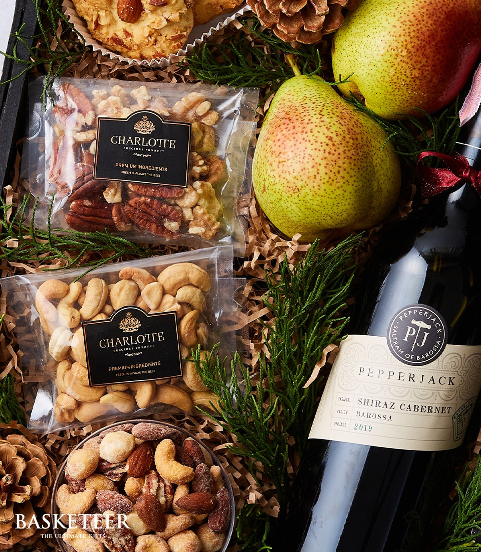Elegant wine gift basket with red Pepperjack Shiraz, fresh pears, gourmet nuts, and festive greenery