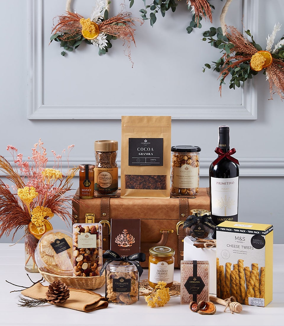 Luxury wine hamper with red wine, artisan coffee, nuts, preserves, and gourmet treats in leather trunk
