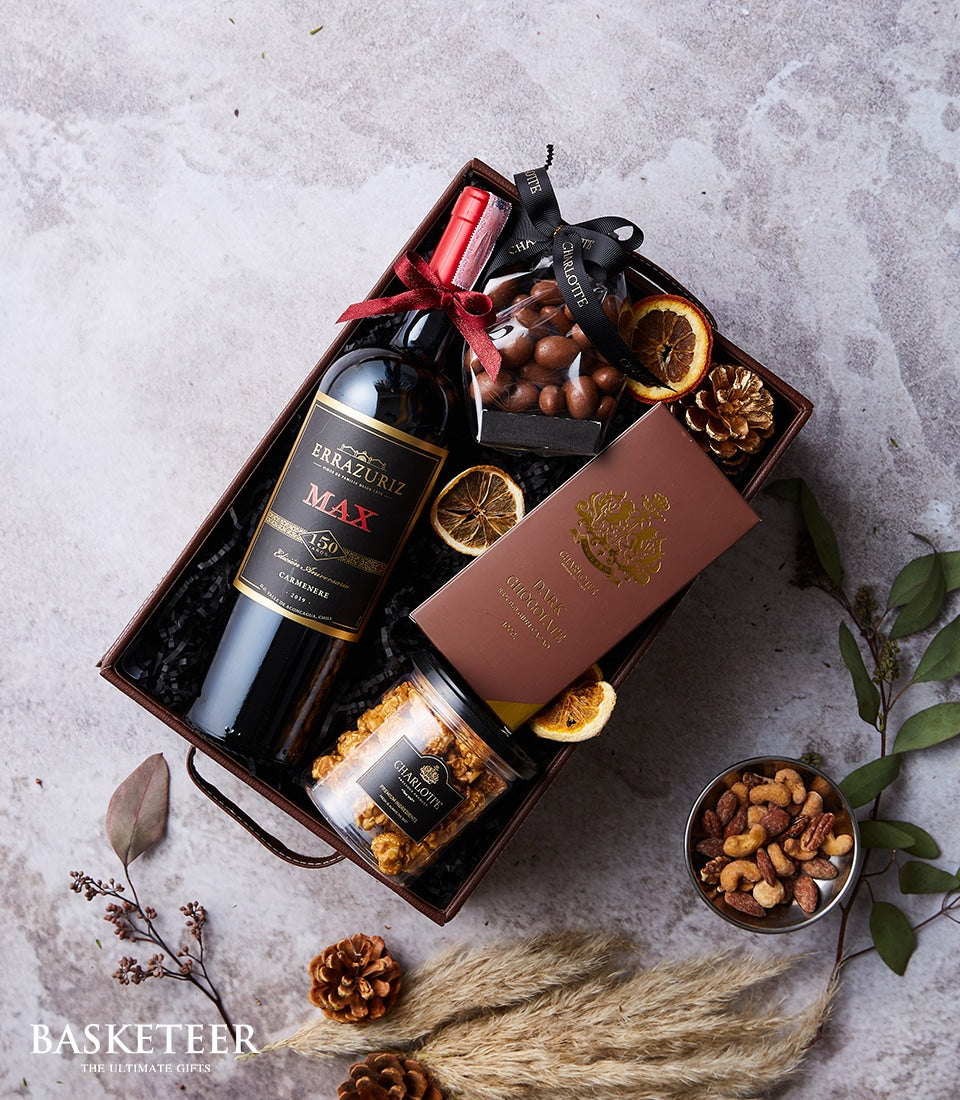 Premium wine and gourmet chocolate gift basket with nuts, caramel popcorn, and artisan treats in elegant brown wicker