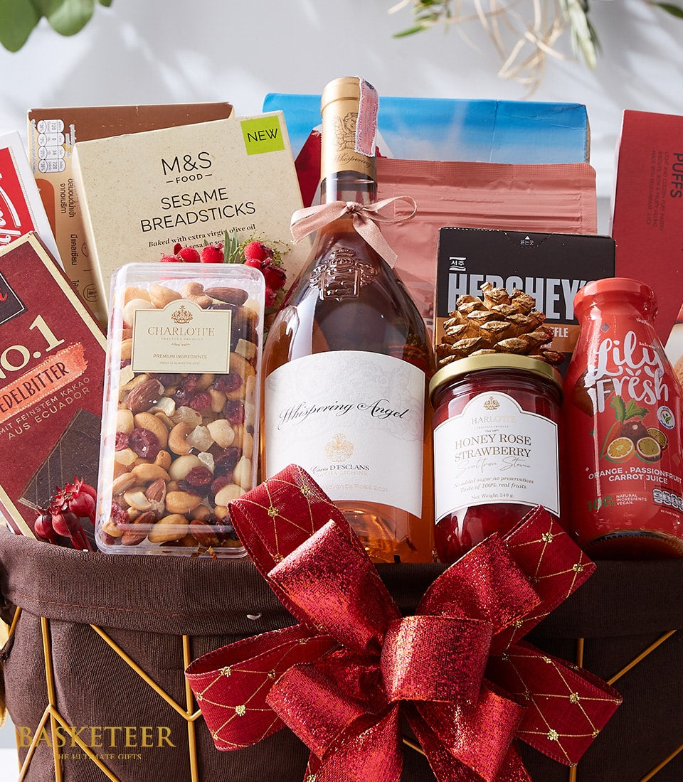 Luxury rosé wine gift basket with gourmet spreads, nuts, breadsticks, and chocolate