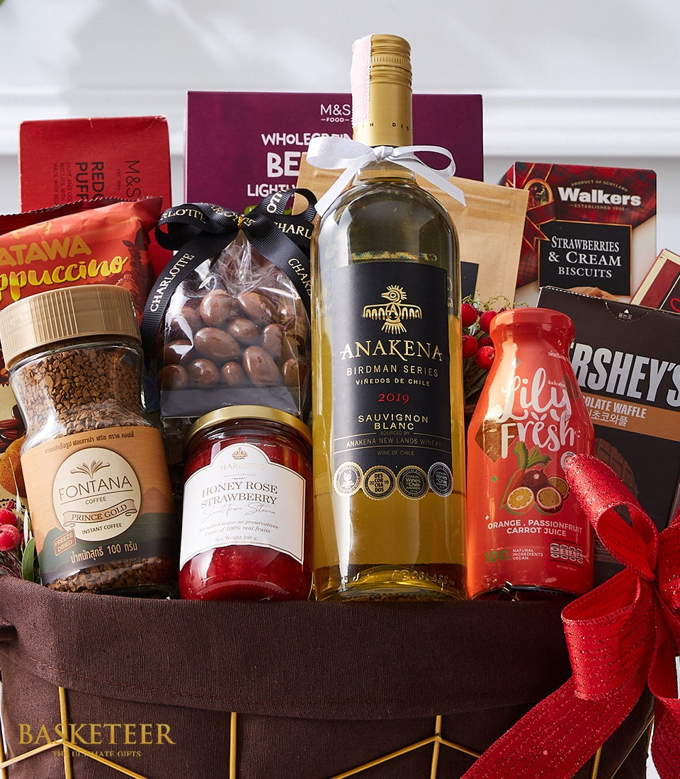Luxury white wine gift basket with gourmet coffee, jam, chocolate nuts, and artisan snacks in dark woven basket