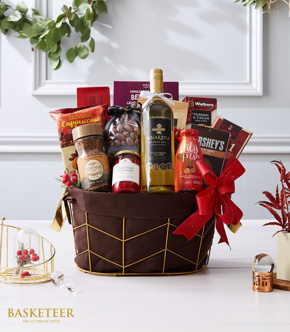 White wine gourmet gift basket with coffee, jam, nuts, and chocolates, gold-framed dark brown basket with red bow