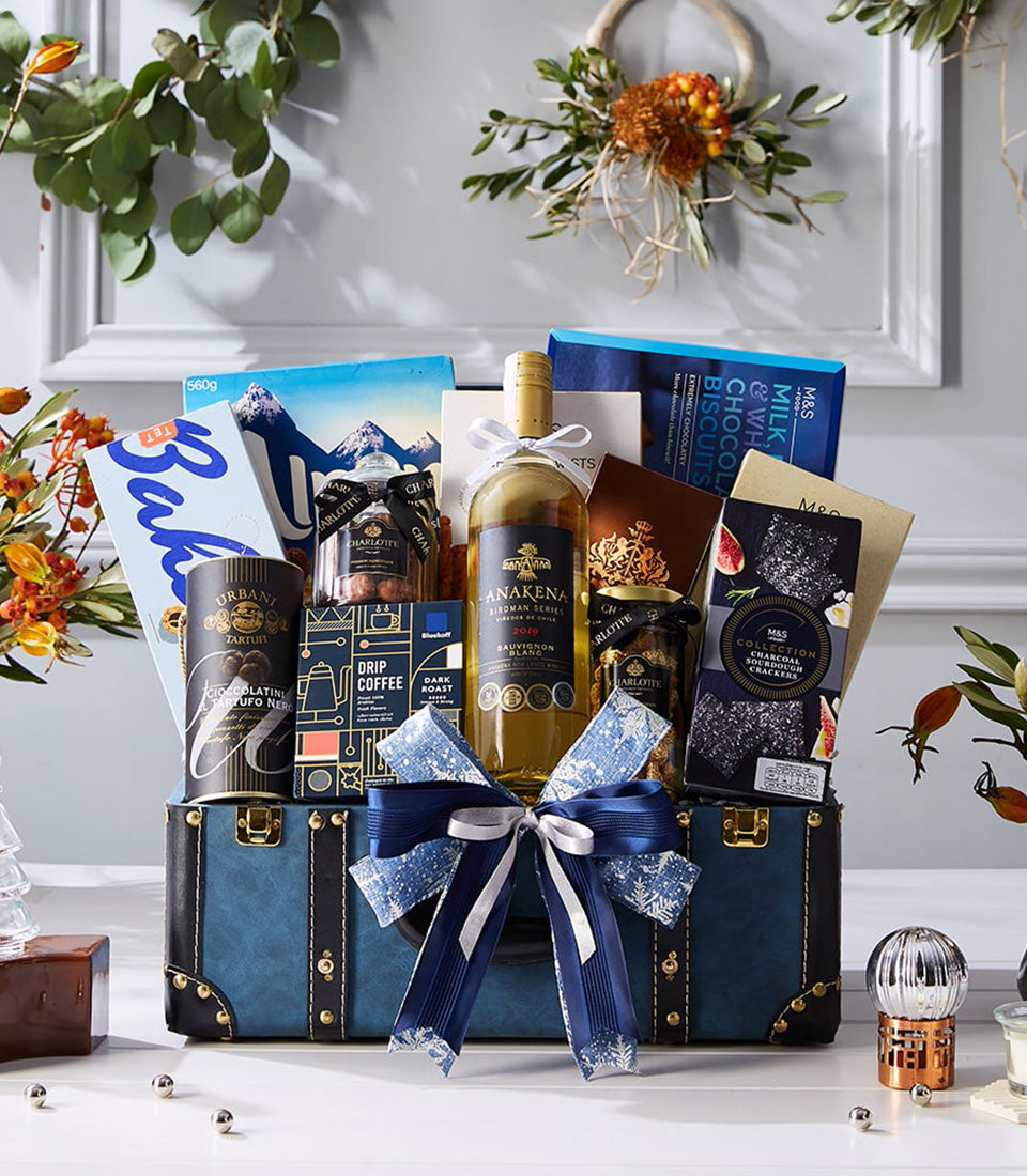 Luxury blue trunk hamper with white wine, chocolate truffles, gourmet crackers, and artisan gifts